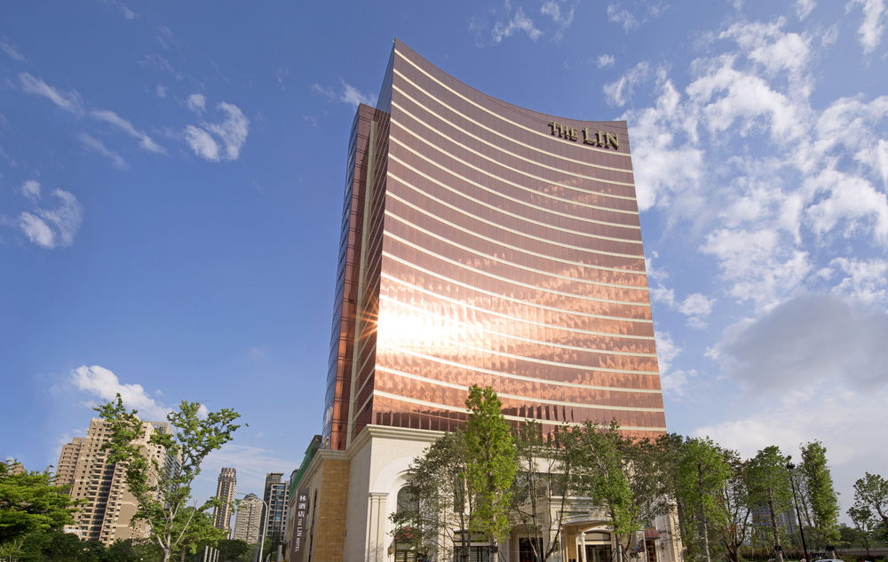 The Lin Hotel Taichung's iconic golden façade towering over the city skyline during the day.