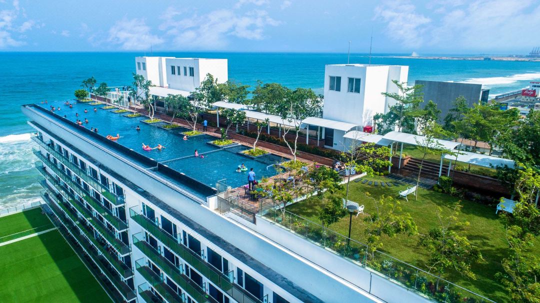 A 60-meter rooftop infinity pool at Marino Beach Colombo merging with the Indian Ocean horizon at dusk.